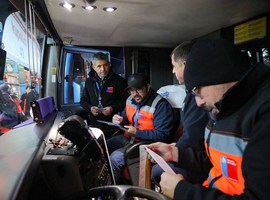 Tres fiscalizadores de la Dirección del Trabajo verifican la jornada de manejo de un chofer de bus interprovincial.