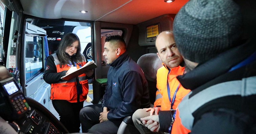 Una fiscalizadora de la Dirección del Trabajo interroga a un chofer de bus interprovincial en su cabina.